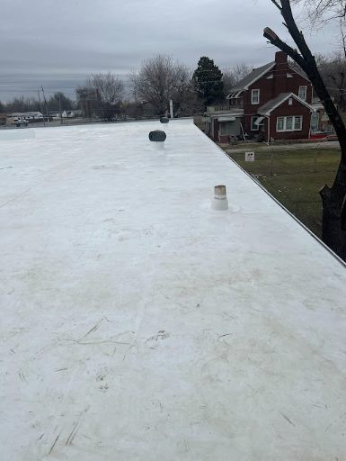 After: new white flat roof membrane, same building