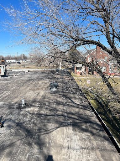 Before: weathered flat roof membrane