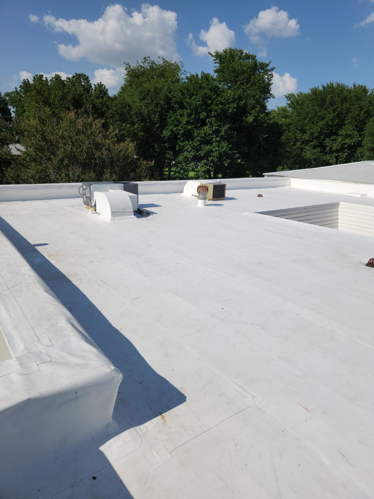 Newly installed TPO roof membrane, wrapped parapet edge